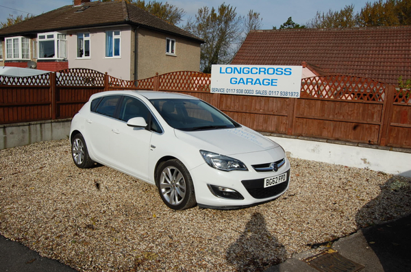 A white Vauxhall hatchback in front of the Longcross Garage sign