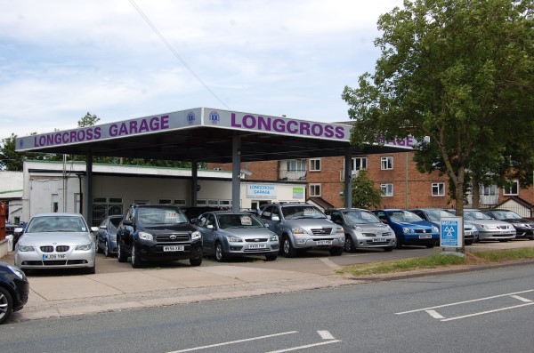 The Longcross Garage canopy and forecourt from the road, cars lined up underneath it