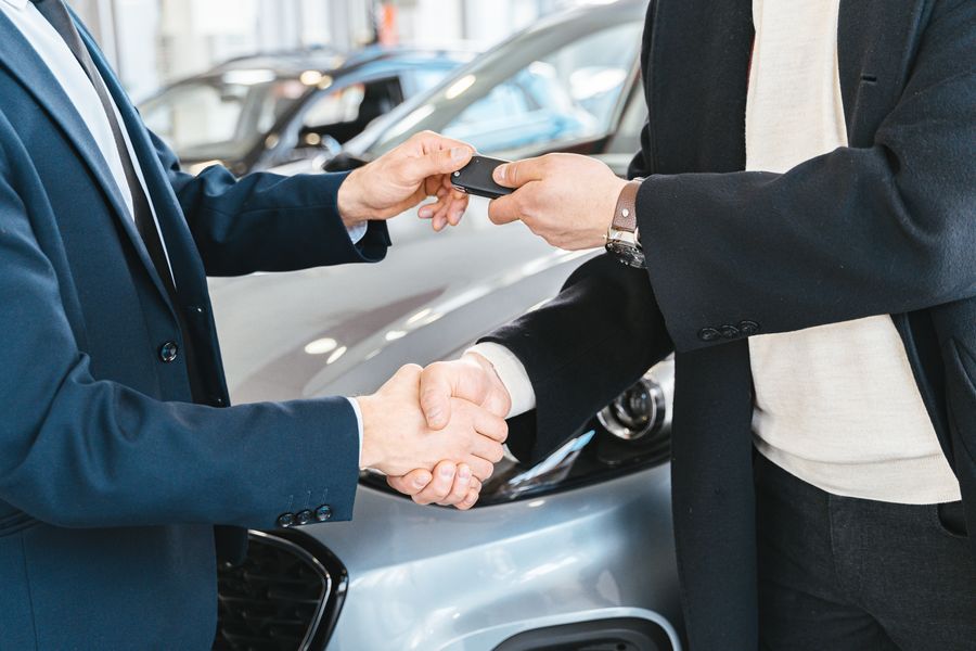 A handshake over a car bonnet as the keys change hands
