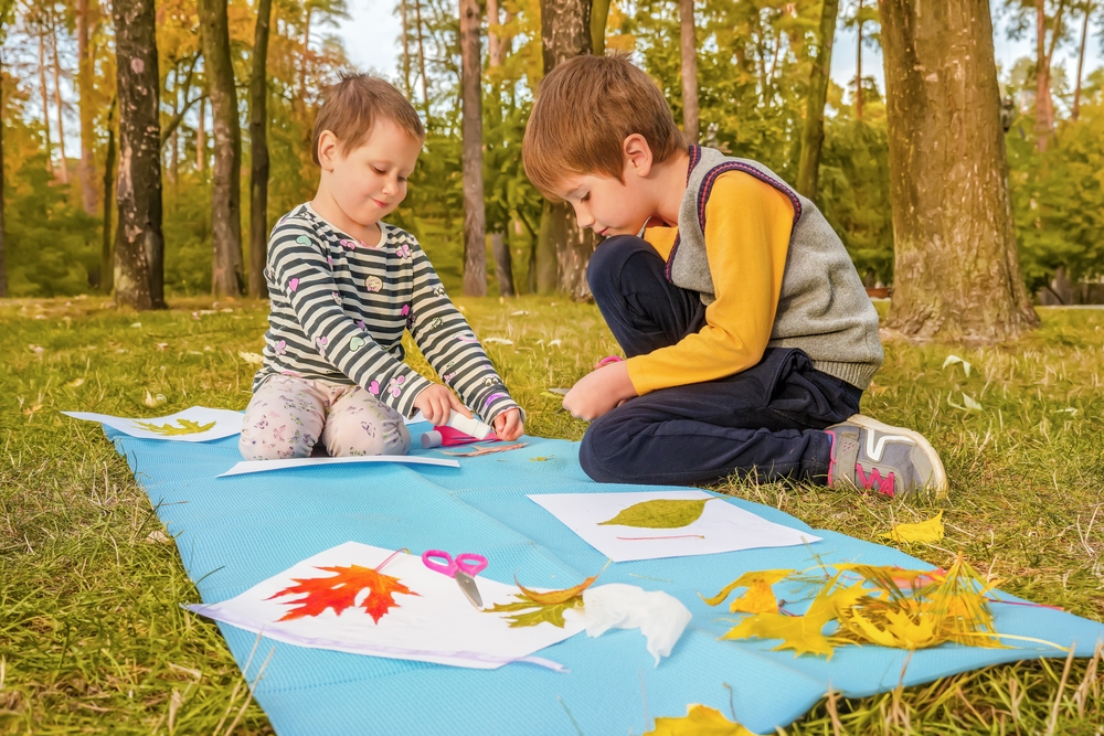 Kids craft with autumn leaves in a woodland