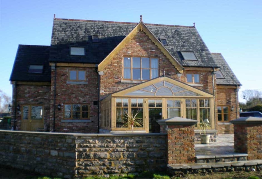 The finished house at Brookthorpe, stone and glass, scaffolding gone