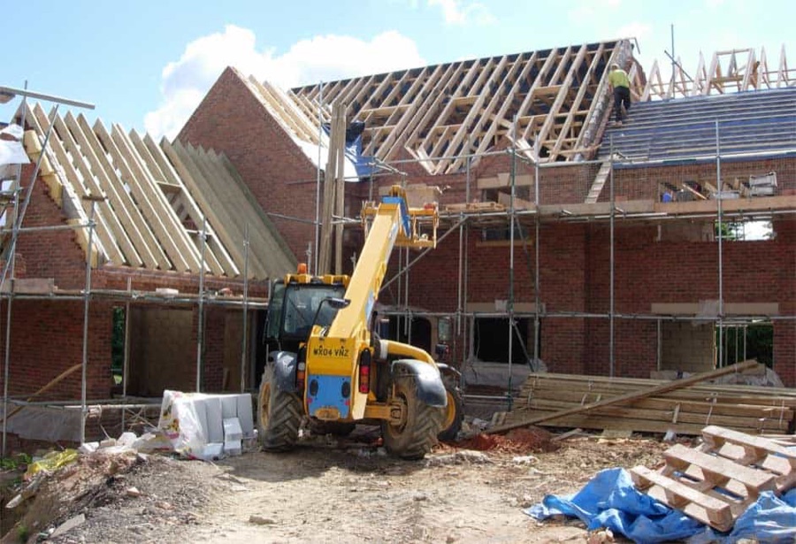 Roof trusses going on at Mulberry Gardens, the telehandler alongside