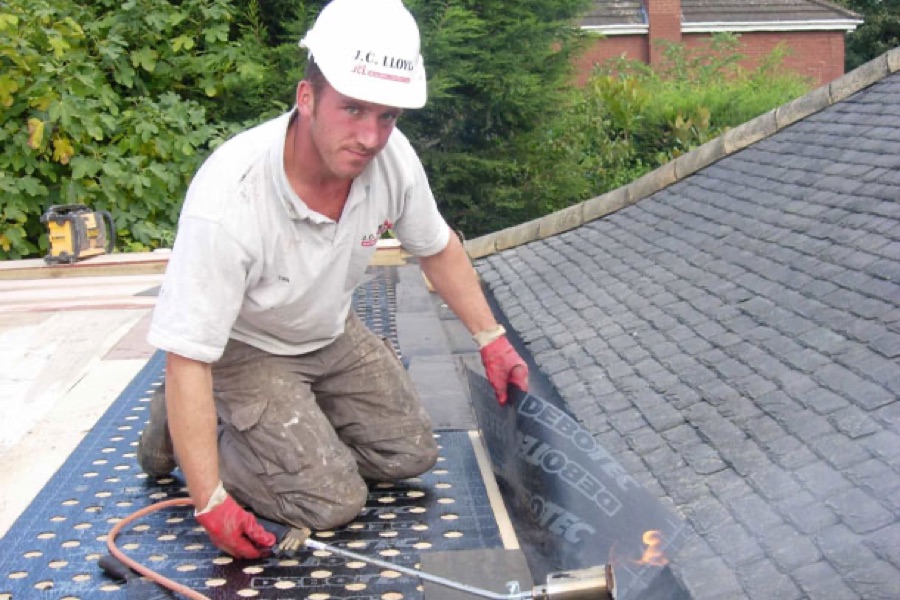 A J C Lloyd roofer fitting lead on a slate roof