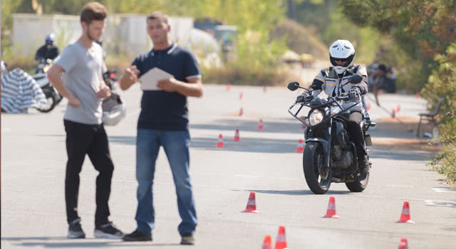 A rider and an instructor with cones at a training session