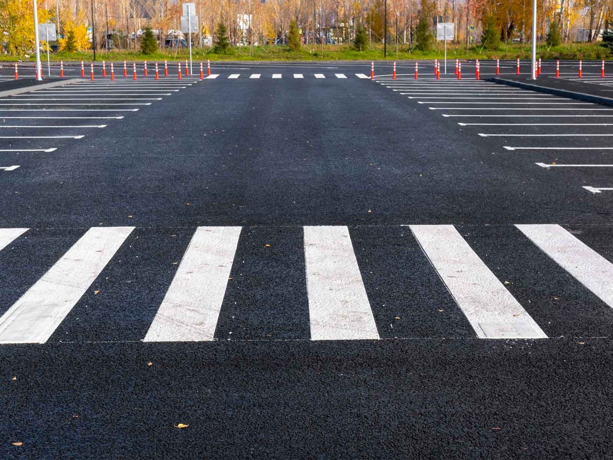 A freshly surfaced car park with a white zebra crossing