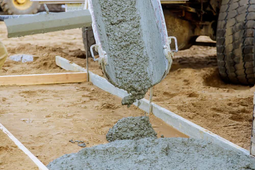 Concrete running down a mixer's chute into timber formwork