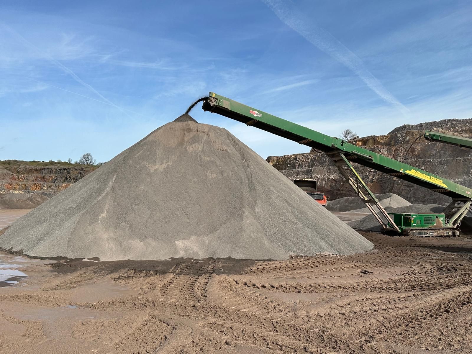 A stacking conveyor building a cone of crushed stone at the quarry