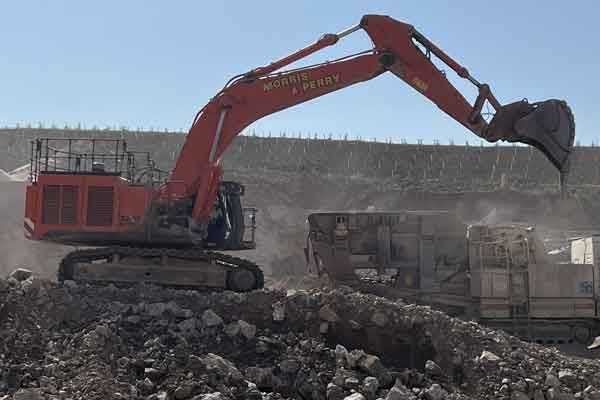 A tracked excavator loading stone at the quarry