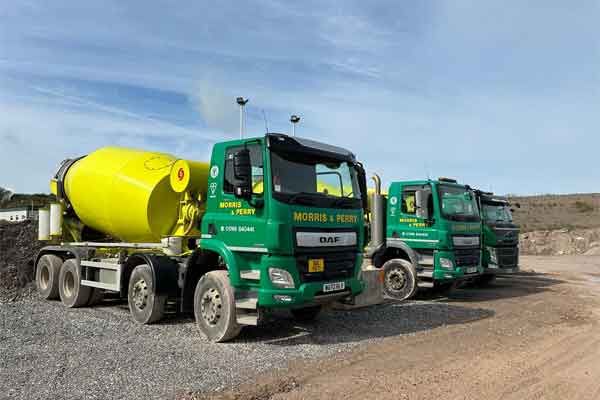 Morris & Perry concrete mixers in green and yellow livery lined up at the yard