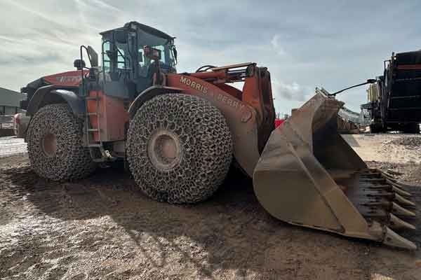 A large wheeled loading shovel with chained tyres at the quarry