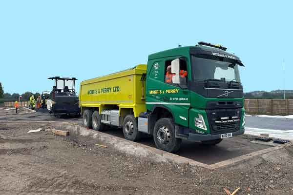 A Morris & Perry eight-wheel tipper, green cab and yellow body, on site