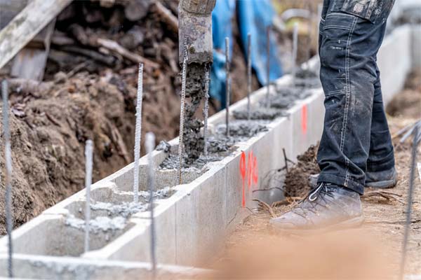 Concrete being poured into a block-lined footing