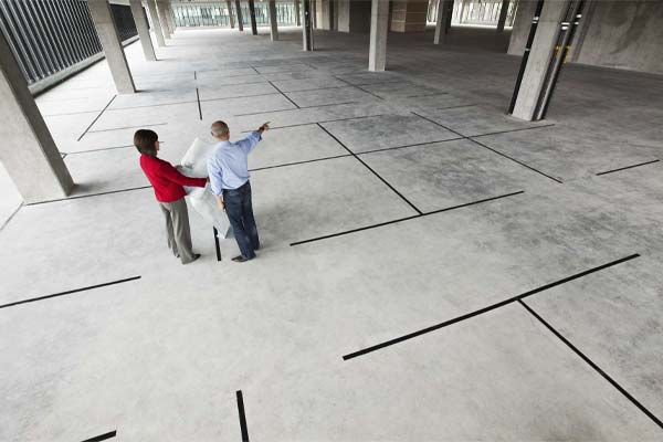Two people talking on a wide, jointed concrete hardstanding
